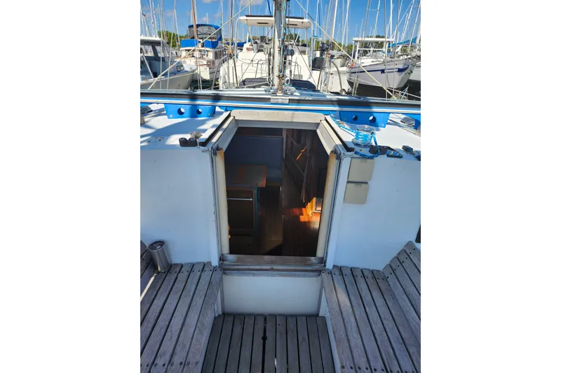 Slide: The Image of 1987 Custom Weld Exploration boat interior view with open cabin door, docked among other boats. - 50