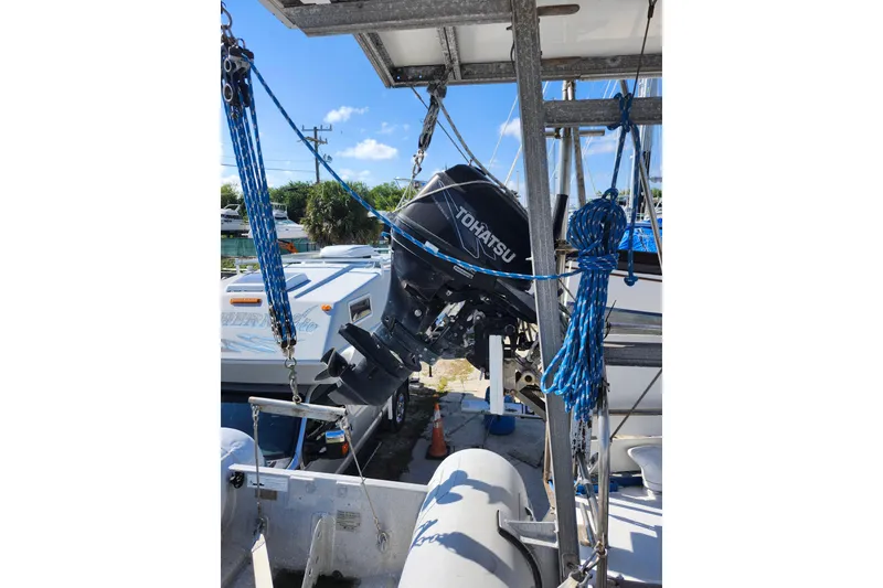 Slide: The Image of Outboard motor on a Custom Weld Exploration boat, 1987 model, docked with blue ropes. - 52