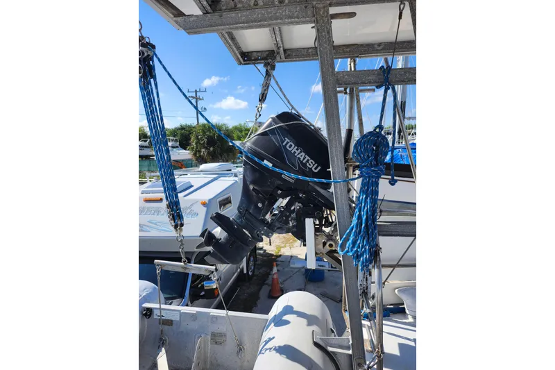 Slide: The Image of Outboard motor on a Custom Weld Exploration boat, 1987 model, docked with blue ropes. - 53