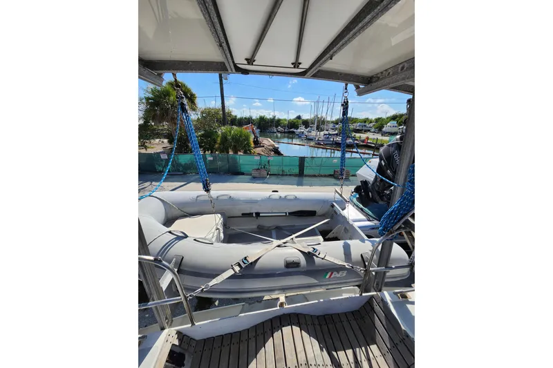 Slide: The Image of 1987 Custom Weld Exploration boat with inflatable dinghy, docked at marina under clear skies. - 6
