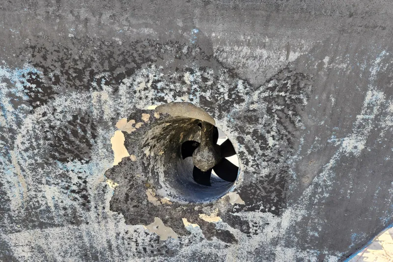 Slide: The Image of Propeller of 1987 Custom Weld Exploration boat with weathered hull surface. - 9