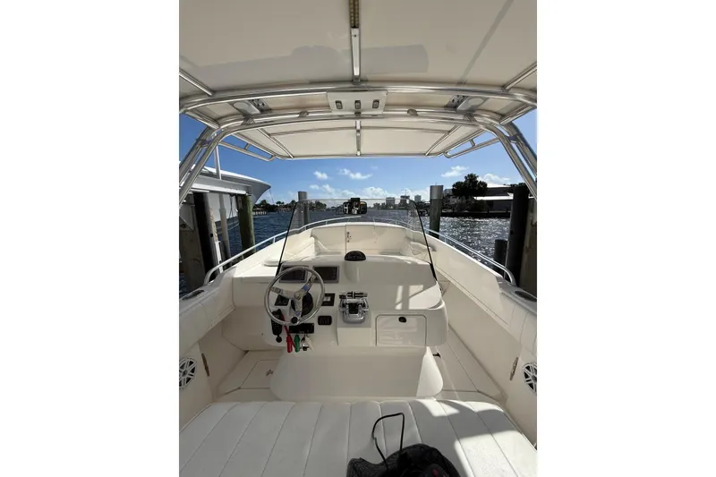 Slide: The Image of 2010 Intrepid 323 Cuddy boat interior with steering wheel and waterfront view. - 11