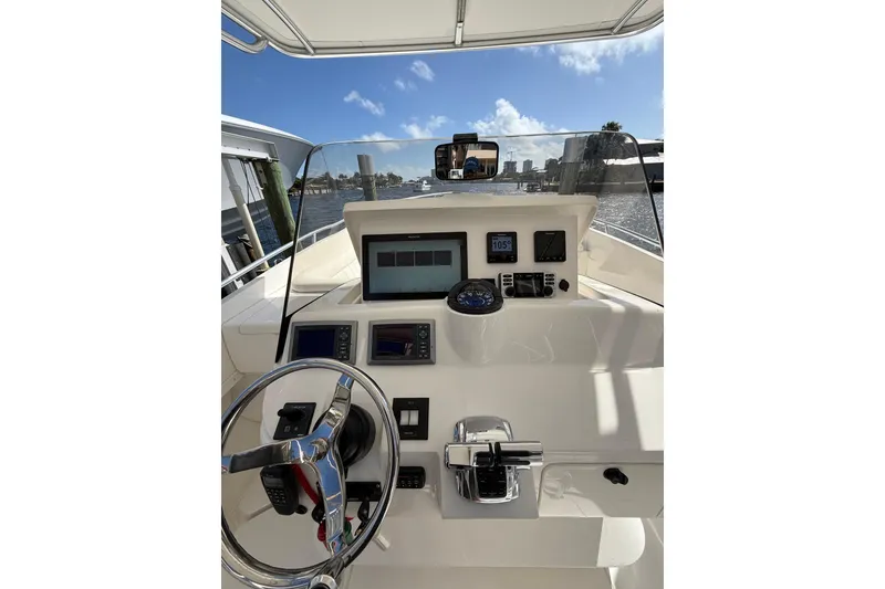 Slide: The Image of 2010 Intrepid 323 Cuddy boat dashboard with steering wheel and navigation instruments. - 12