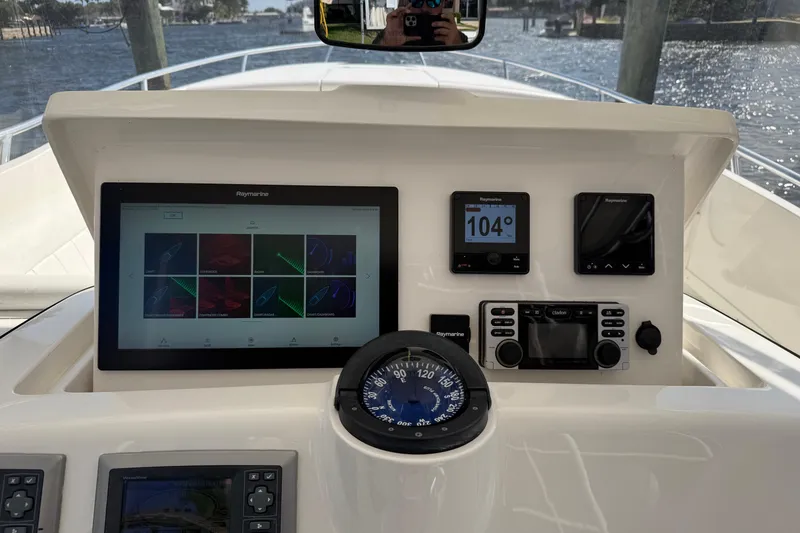 Slide: The Image of 2010 Intrepid 323 Cuddy dashboard with navigation and control systems. - 13