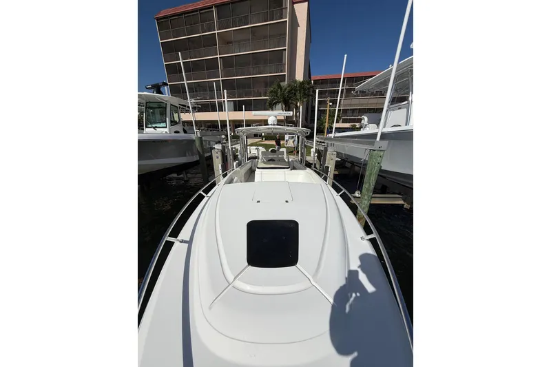 Slide: The Image of 2010 Intrepid 323 Cuddy boat docked, with modern design and sleek white exterior. - 17