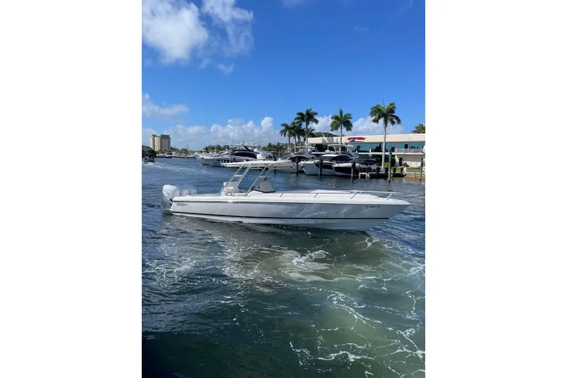 Slide: The Image of 2010 Intrepid 323 Cuddy boat cruising on a sunny day near a marina. - 3