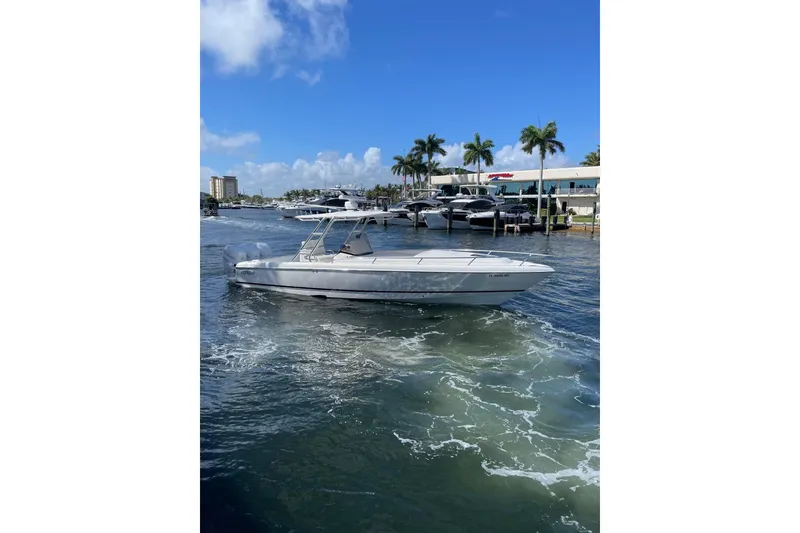 Slide: The Image of 2010 Intrepid 323 Cuddy boat cruising on a sunny day near a marina. - 4