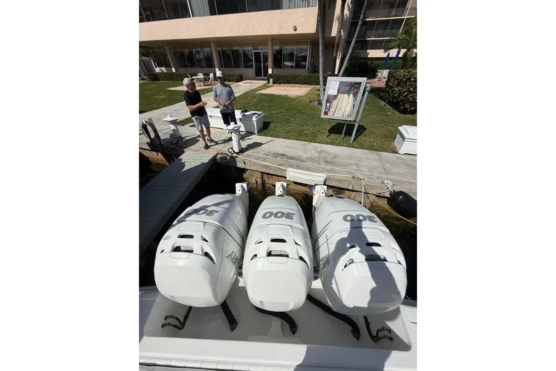 Slide: The Image of 2010 Intrepid 323 Cuddy with triple 300 horsepower engines docked near a building. - 6