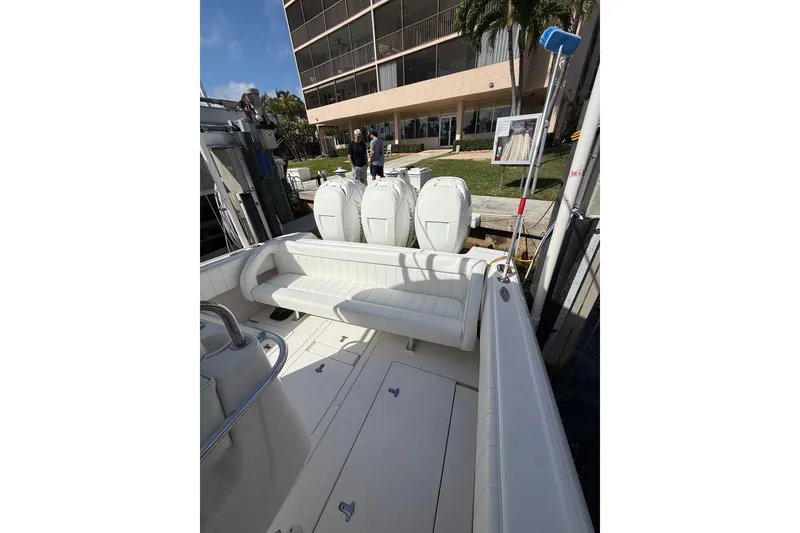 Slide: The Image of 2010 Intrepid 323 Cuddy boat with white seating and triple outboard engines. - 7