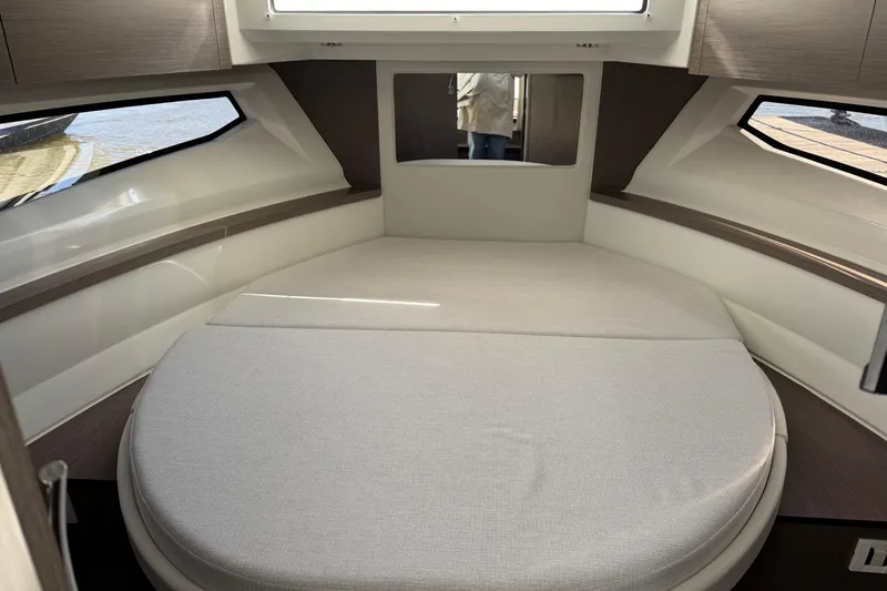 Slide: The Image of 2024 Jeanneau NC 895 Series 2 cabin interior with round bed and windows. - 10