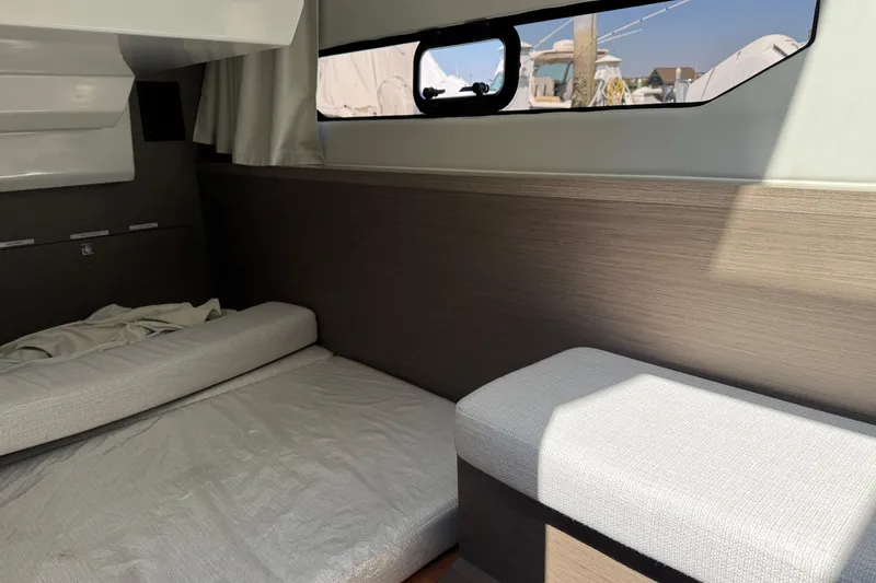 Slide: The Image of 2024 Jeanneau NC 895 Series 2 cabin interior with bed and window view. - 11