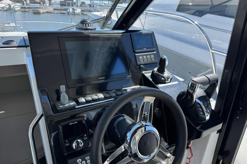 Slide: The Image of 2024 Jeanneau NC 895 Series 2 helm with modern navigation controls and steering wheel. - 16