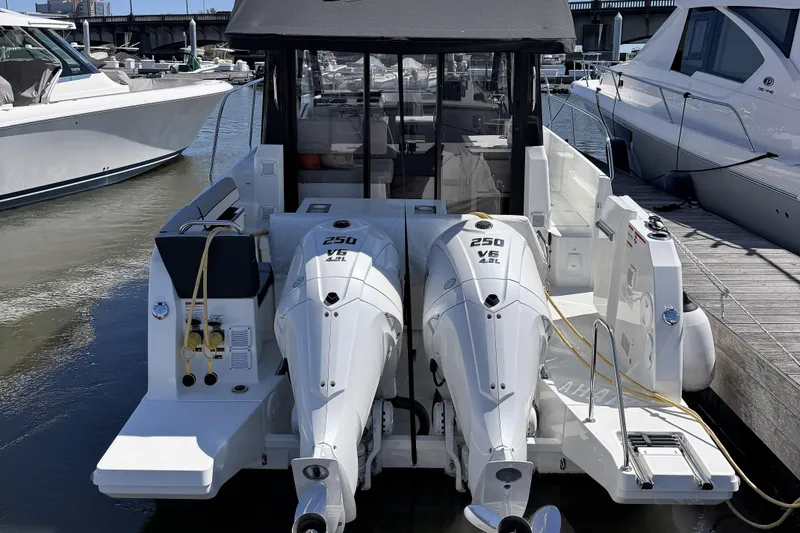 Slide: The Image of 2024 Jeanneau NC 895 Series 2 boat with dual 250 V6 engines docked at marina. - 2