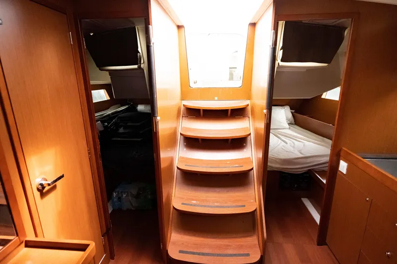 Slide: The Image of Interior of 2017 Beneteau Oceanis 41.1 yacht, featuring wooden stairs and cozy cabins. - 26