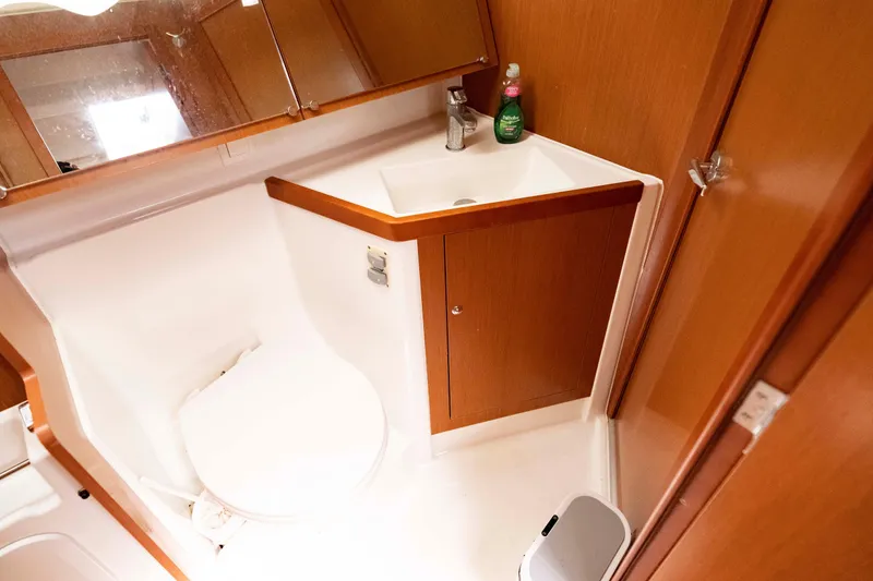 Slide: The Image of 2017 Beneteau Oceanis 41.1 yacht bathroom with wooden cabinetry and compact sink area. - 34