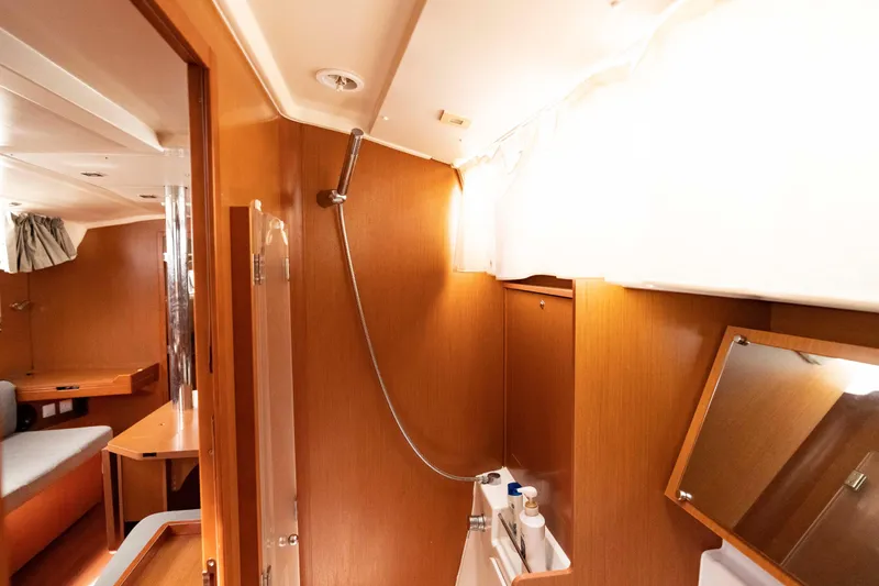 Slide: The Image of Interior of 2017 Beneteau Oceanis 41.1 yacht, featuring a compact bathroom with wooden finish. - 35