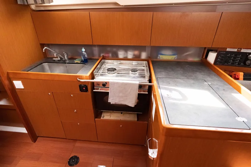 Slide: The Image of 2017 Beneteau Oceanis 41.1 yacht kitchen with sink, stove, and storage cabinets. - 40