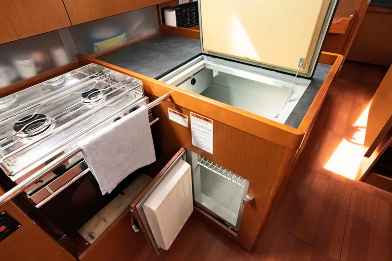 Slide: The Image of Galley kitchen in 2017 Beneteau Oceanis 41.1 yacht with stove and open fridge. - 41