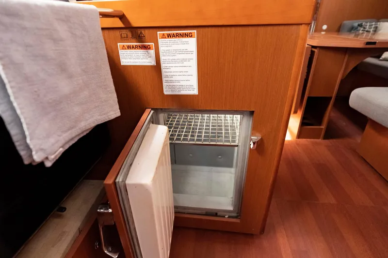 Slide: The Image of Open fridge in 2017 Beneteau Oceanis 41.1 yacht interior with wooden cabinetry. - 43