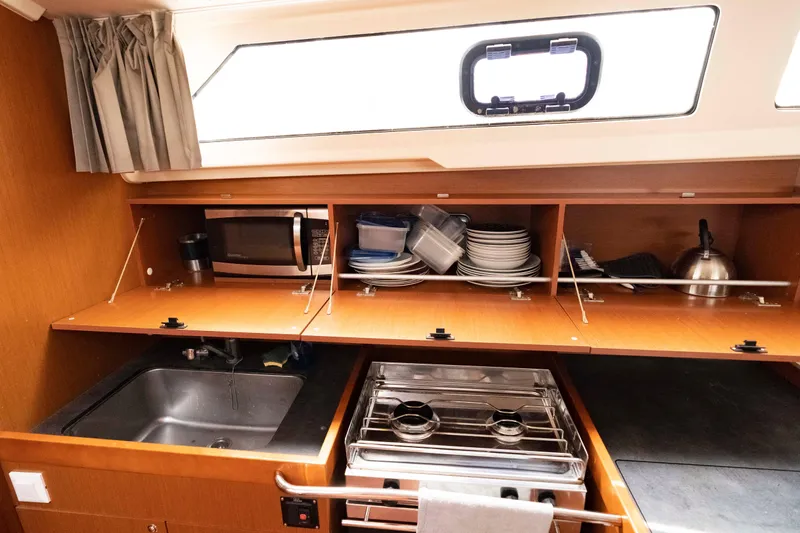 Slide: The Image of Interior galley of 2017 Beneteau Oceanis 41.1 yacht with sink, stove, and storage cabinets. - 44