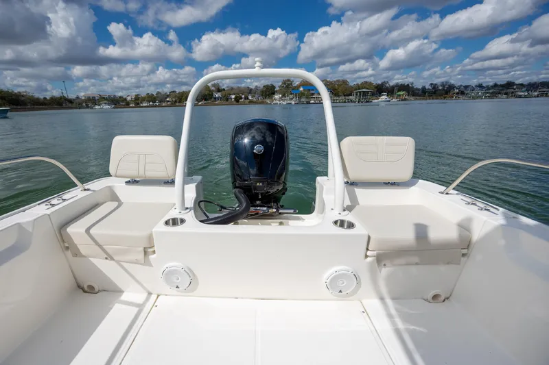 Slide: The Image of 2022 Boston Whaler 190 Montauk boat interior with outboard motor on calm water. - 10