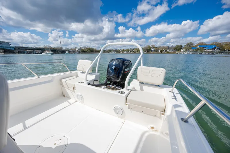 Slide: The Image of 2022 Boston Whaler 190 Montauk boat on calm water under a partly cloudy sky. - 11