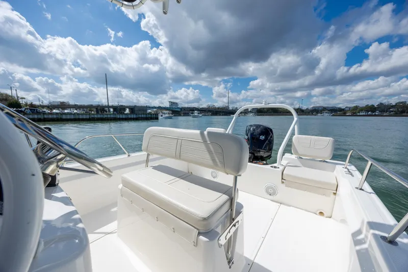 Slide: The Image of 2022 Boston Whaler 190 Montauk boat interior with seating, on a sunny day by the water. - 12
