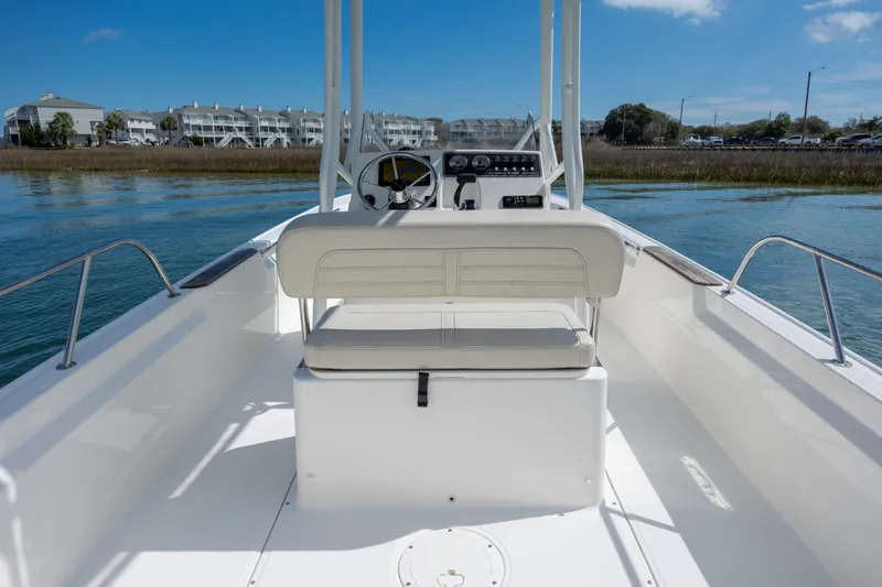 Slide: The Image of 2022 Boston Whaler 190 Montauk boat interior with steering console on calm water. - 14