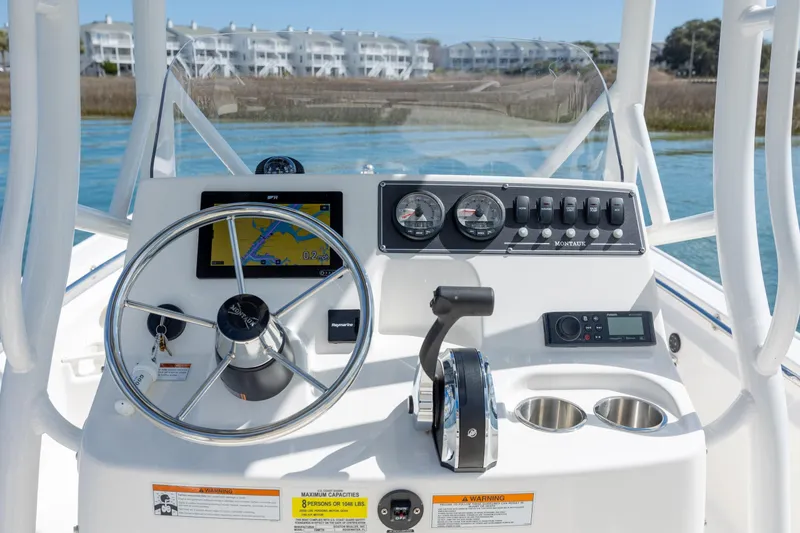 Slide: The Image of 2022 Boston Whaler 190 Montauk boat dashboard with steering wheel and navigation controls. - 16
