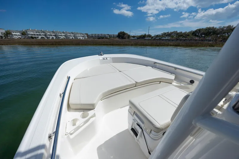 Slide: The Image of 2022 Boston Whaler 190 Montauk boat interior with cushioned seating on calm water. - 18