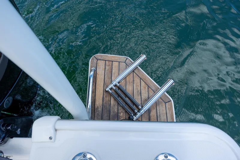 Slide: The Image of 2022 Boston Whaler 190 Montauk swim platform with ladder on water. - 27