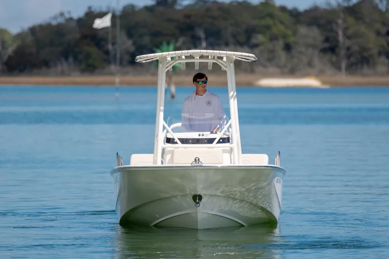 Slide: The Image of 2022 Boston Whaler 190 Montauk boat cruising on calm water with a person at the helm. - 4