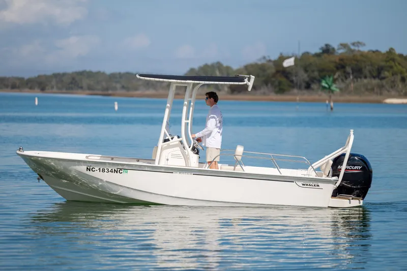 Slide: The Image of 2022 Boston Whaler 190 Montauk boat cruising on calm water with a person at the helm. - 6