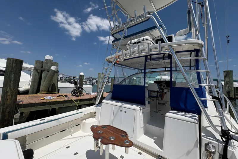 Slide: The Image of 2006 Rampage 38 Express boat docked, featuring spacious deck and fishing equipment. - 12