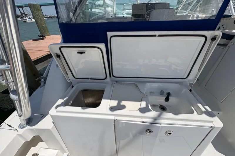 Slide: The Image of 2006 Rampage 38 Express boat with open storage compartments and sink on deck. - 16