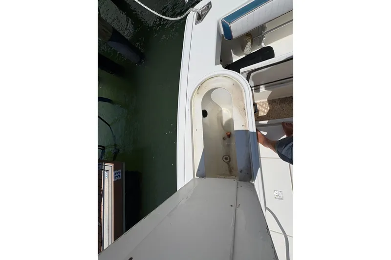 Slide: The Image of 2006 Rampage 38 Express boat interior, showing seating and storage area near the dock. - 18