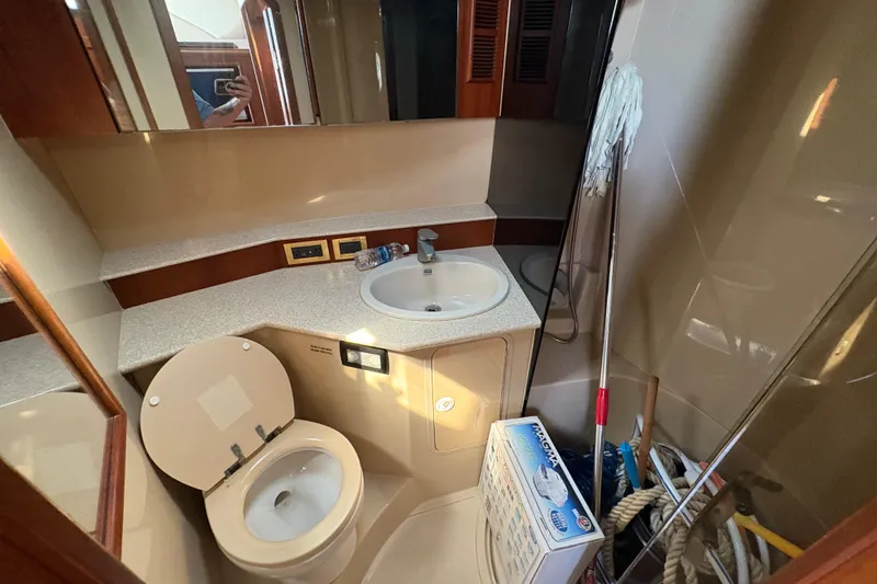 Slide: The Image of 2006 Rampage 38 Express yacht bathroom with sink, toilet, and cleaning supplies. - 29
