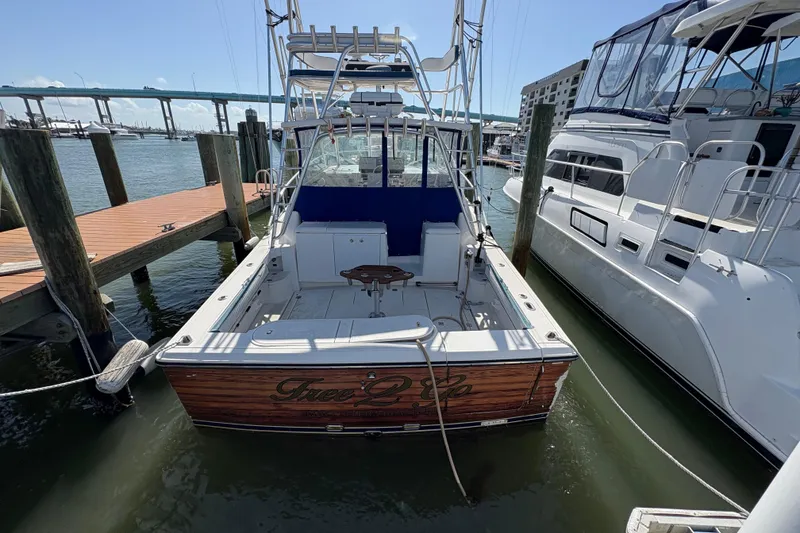 Slide: The Image of 2006 Rampage 38 Express boat docked at marina, featuring spacious deck and fishing equipment. - 6
