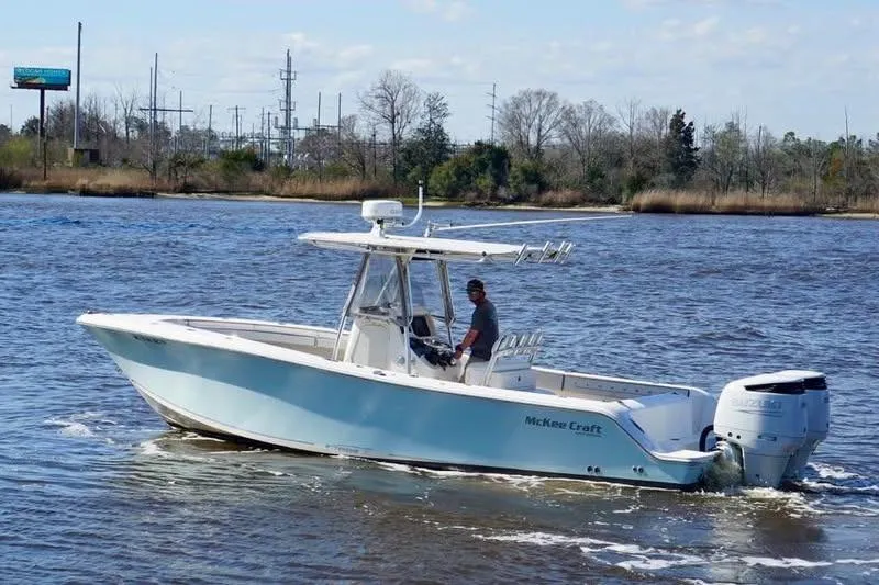 The Image of 2006 McKee Craft Freedom 28 FS/CC boat cruising on a calm river. - 1