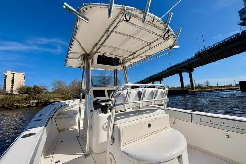 Slide: The Image of 2006 McKee Craft Freedom 28 FS/CC boat on water near a bridge, clear sky. - 10