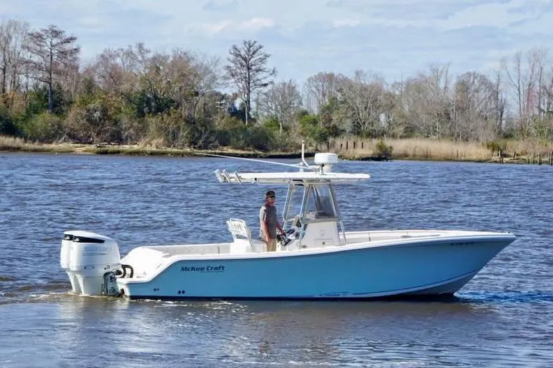 Slide: The Image of 2006 McKee Craft Freedom 28 FS/CC boat on a calm river with trees in the background. - 3