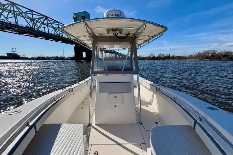 Slide: The Image of 2006 McKee Craft Freedom 28 FS/CC boat on water near a bridge, clear sky. - 8