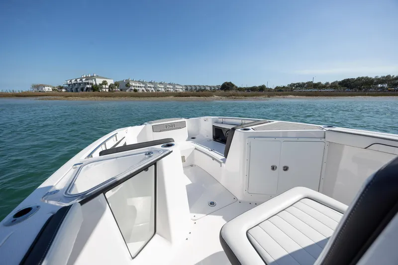 Slide: The Image of 2023 Yamaha Boats 255 FSH Sport E on water, showcasing sleek design and spacious seating. - 10