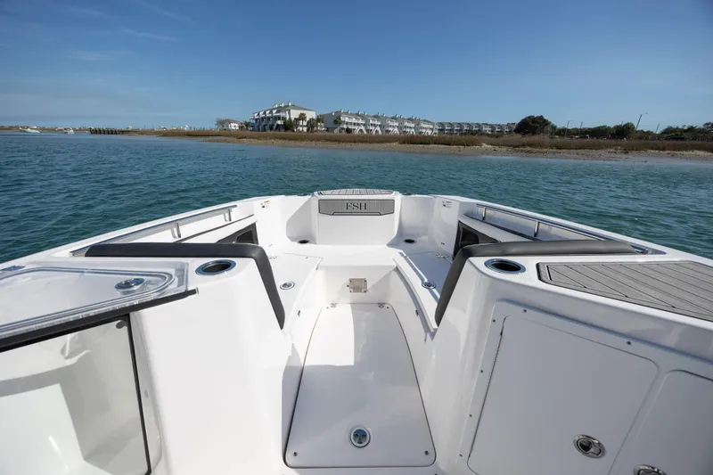 Slide: The Image of 2023 Yamaha Boats 255 FSH Sport E on water, showcasing spacious deck and seating. - 11