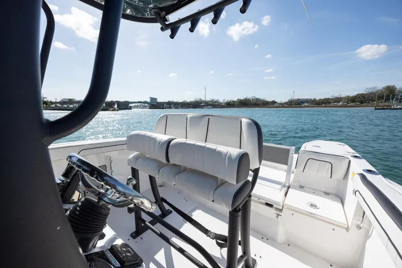 Slide: The Image of 2023 Yamaha Boats 255 FSH Sport E interior with seating, overlooking serene water. - 17