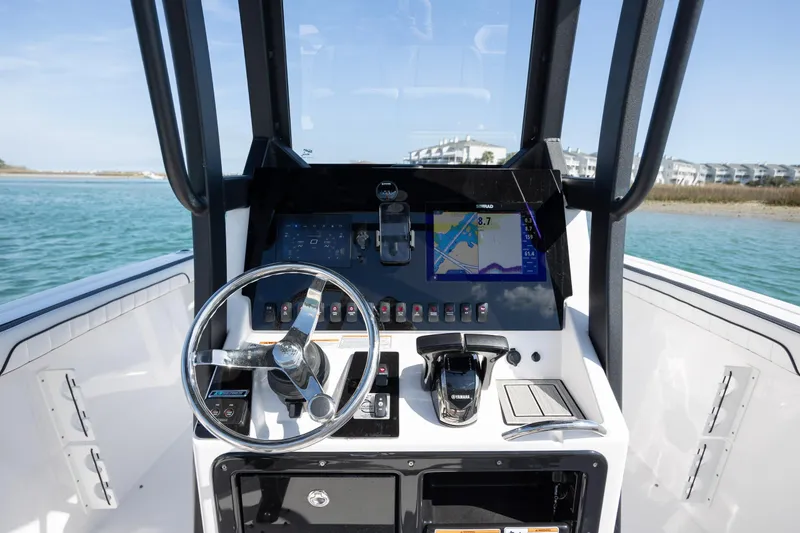 Slide: The Image of 2023 Yamaha Boats 255 FSH Sport E dashboard with steering wheel and navigation display. - 19
