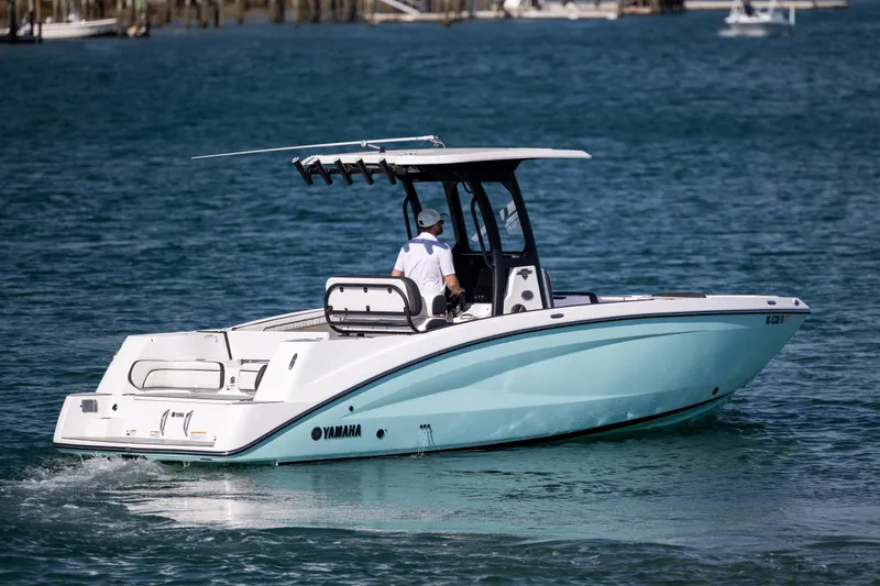 Slide: The Image of 2023 Yamaha Boats 255 FSH Sport E cruising on blue water. - 2