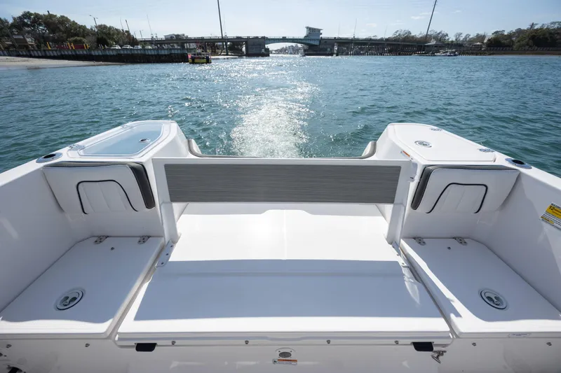 Slide: The Image of 2023 Yamaha Boats 255 FSH Sport E on water, rear view, open deck, sunny day. - 25