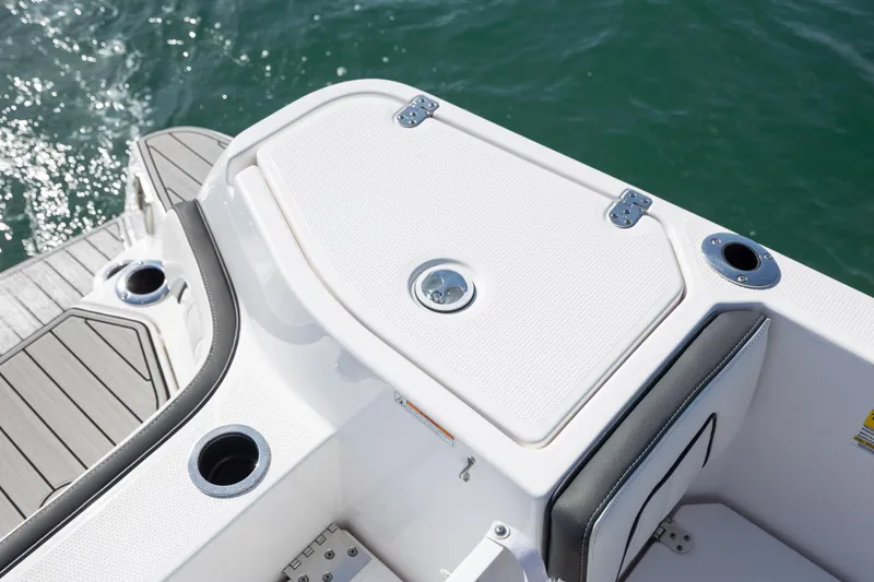 Slide: The Image of 2023 Yamaha Boats 255 FSH Sport E deck detail with cup holders and storage. - 28