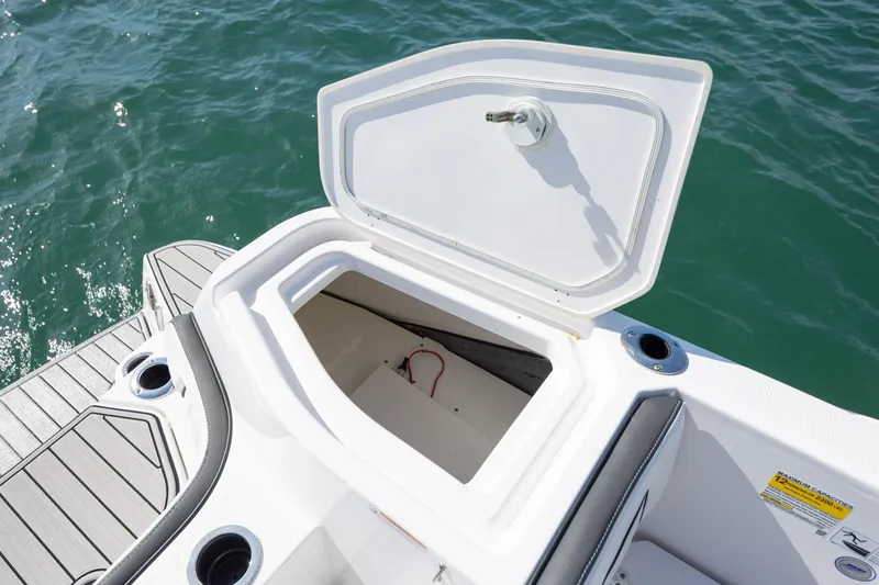 Slide: The Image of Open storage compartment on 2023 Yamaha Boats 255 FSH Sport E, with ocean background. - 29
